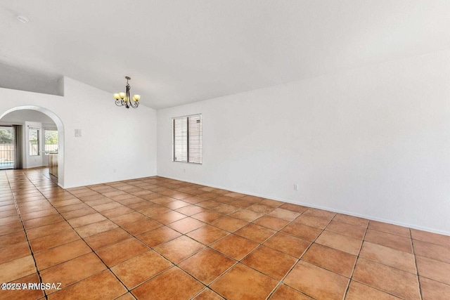 spare room featuring arched walkways, light tile patterned floors, a notable chandelier, and vaulted ceiling