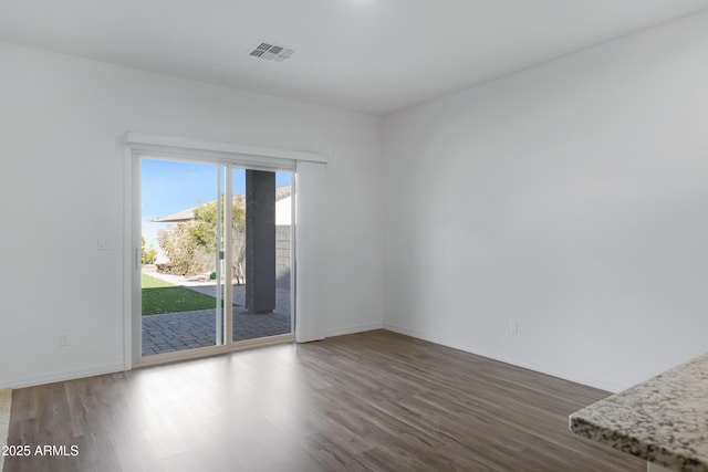 empty room with dark hardwood / wood-style flooring