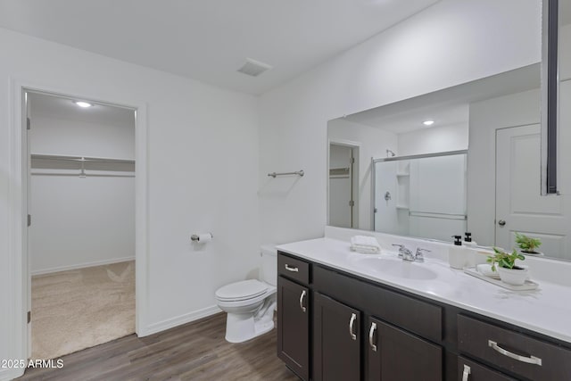 bathroom with walk in shower, vanity, toilet, and hardwood / wood-style flooring