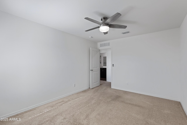 empty room featuring ceiling fan and light colored carpet