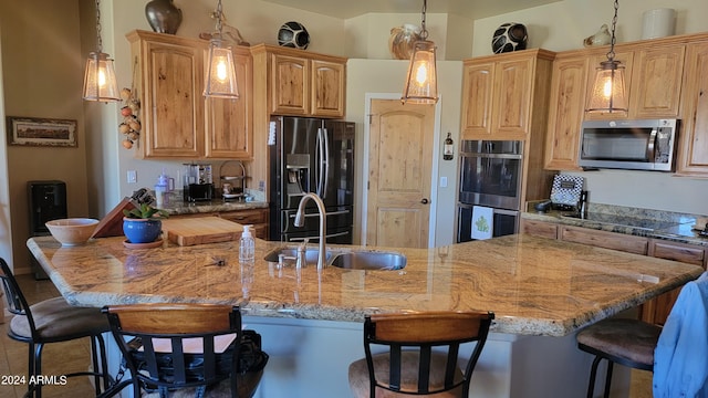 kitchen with a kitchen breakfast bar, pendant lighting, light stone counters, and stainless steel appliances