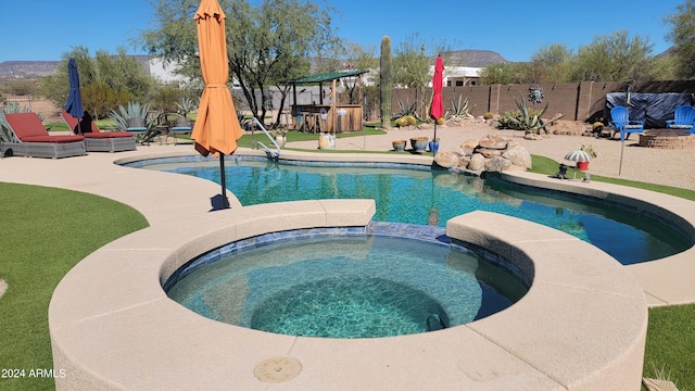 view of pool with an in ground hot tub and a patio