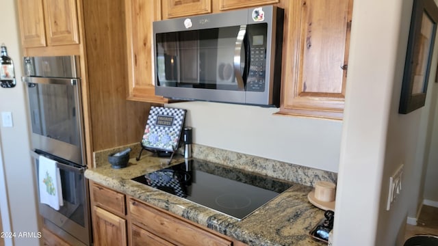 kitchen with appliances with stainless steel finishes and light stone counters