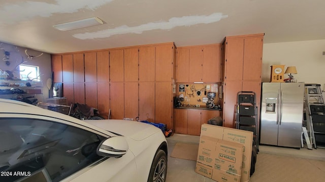 garage with stainless steel refrigerator with ice dispenser