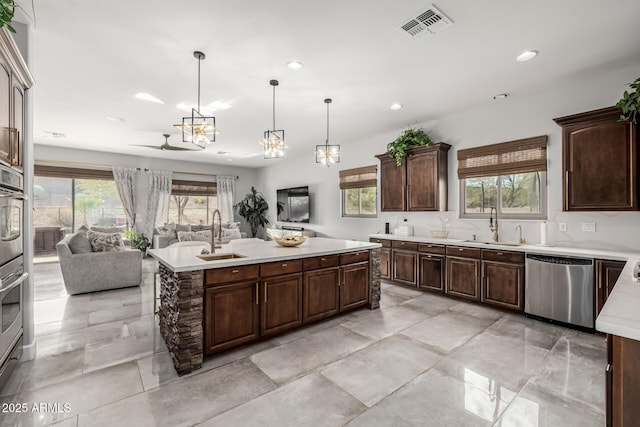 kitchen featuring hanging light fixtures, a center island, sink, and stainless steel dishwasher