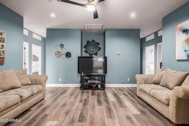 living room featuring wood-type flooring and ceiling fan