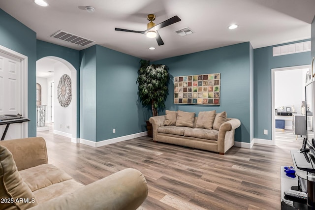 living room with wood-type flooring and ceiling fan