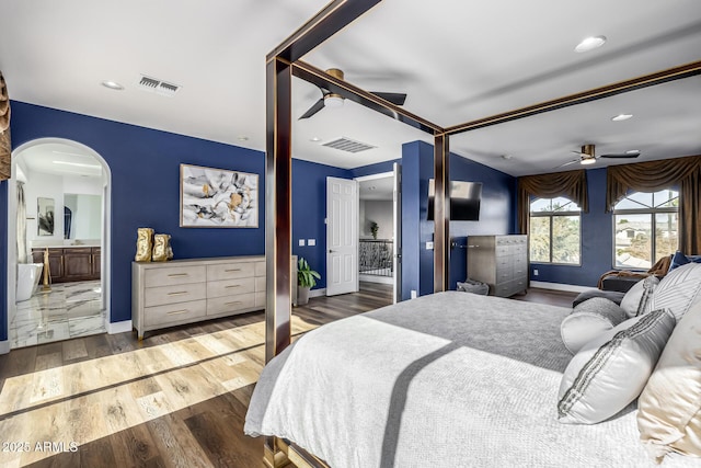 bedroom featuring ceiling fan, connected bathroom, and dark hardwood / wood-style flooring