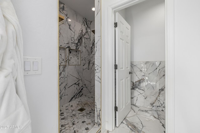 bathroom featuring tiled shower and tile walls