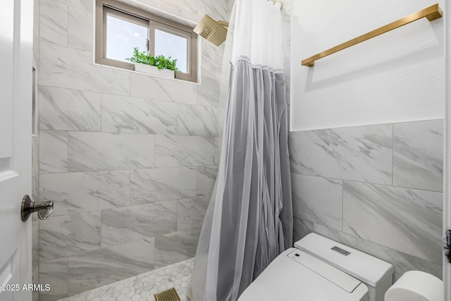 bathroom featuring curtained shower and tile walls