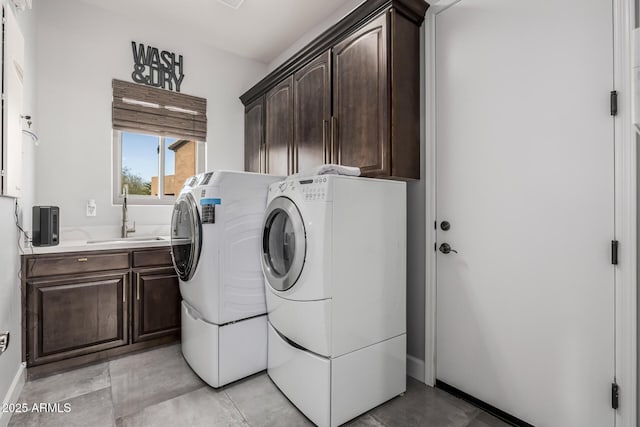 laundry room featuring cabinets, washer and dryer, and sink