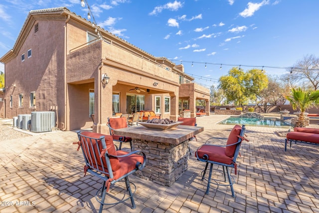 view of patio / terrace with exterior bar, central AC, and ceiling fan