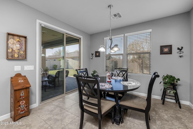 dining room with a chandelier and light tile patterned floors