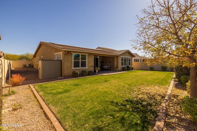 rear view of house with a yard and a patio area