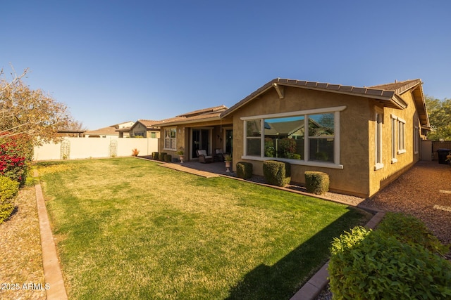 rear view of house with a lawn and a patio area