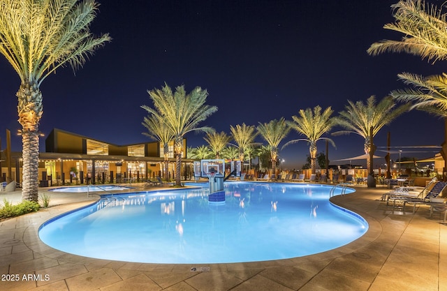 pool at twilight with a patio area