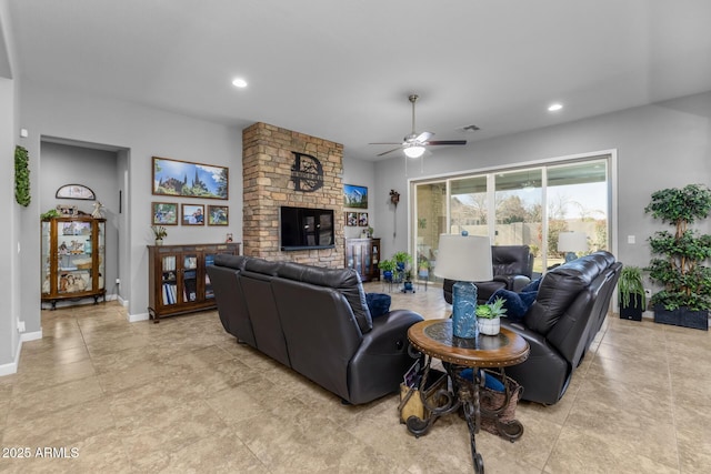 living room featuring ceiling fan and a large fireplace