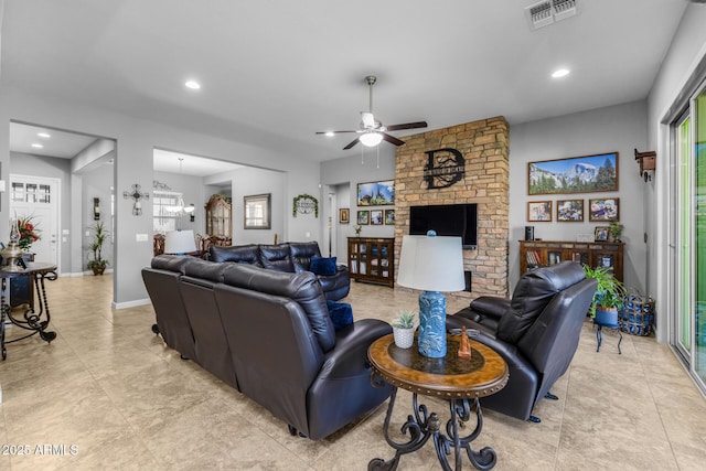 living room featuring ceiling fan, a fireplace, and a wealth of natural light