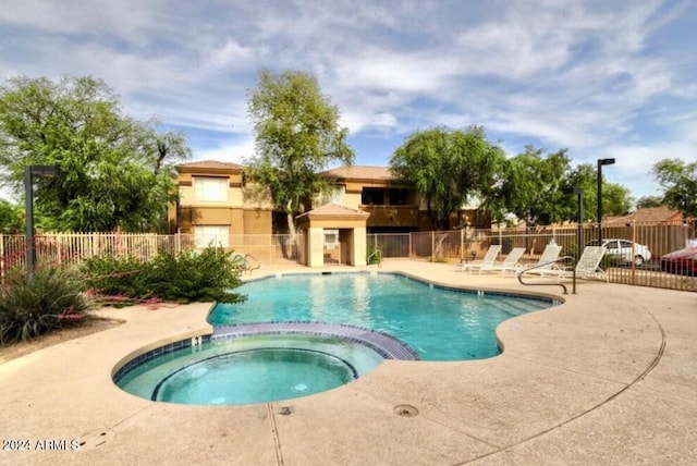 view of swimming pool with a community hot tub and a patio