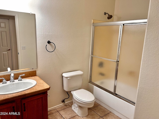 full bathroom with tile patterned flooring, combined bath / shower with glass door, toilet, and vanity