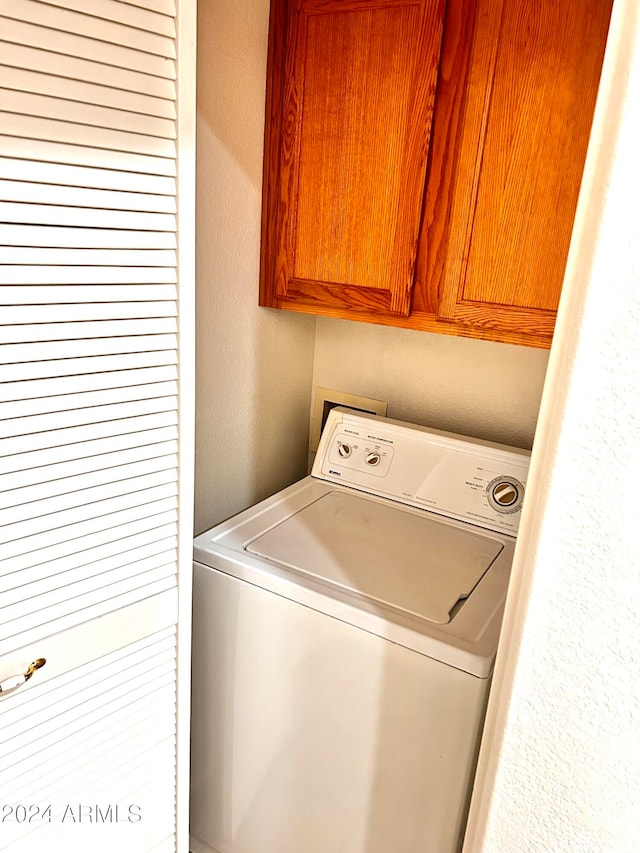 laundry room featuring cabinets and washer / clothes dryer