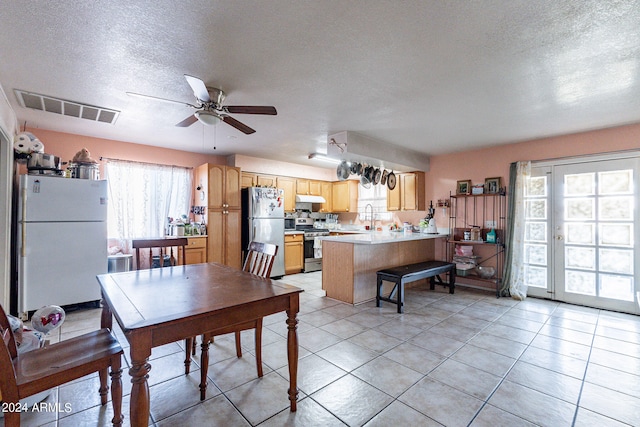 tiled dining room with sink, a textured ceiling, and ceiling fan