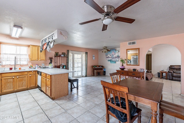 kitchen featuring kitchen peninsula, ceiling fan, light tile patterned floors, a textured ceiling, and sink