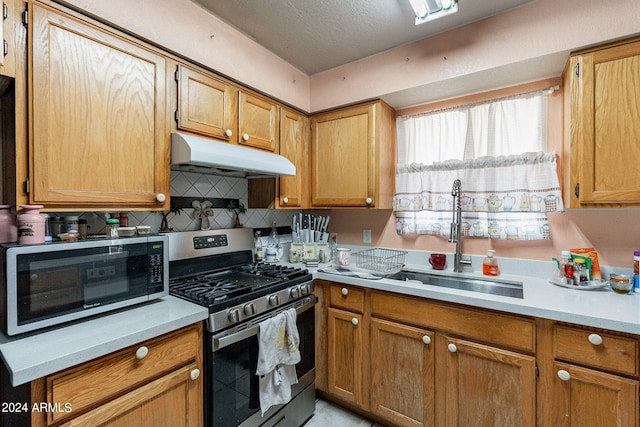 kitchen featuring a textured ceiling, appliances with stainless steel finishes, sink, and decorative backsplash