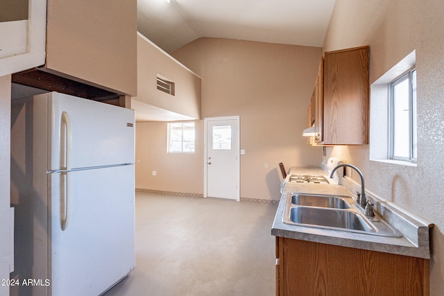 kitchen with a healthy amount of sunlight, lofted ceiling, sink, and white appliances