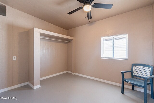 sitting room featuring concrete flooring and ceiling fan