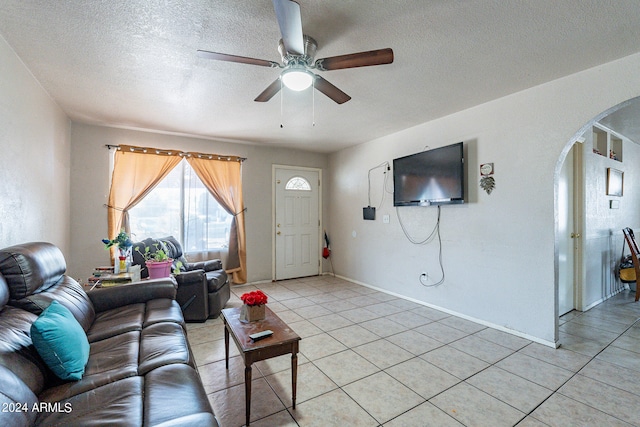 tiled living room with a textured ceiling and ceiling fan