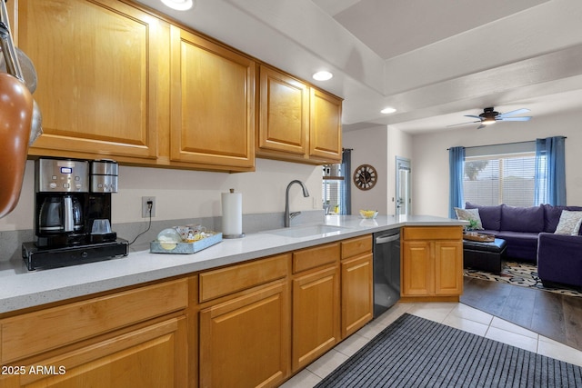 kitchen featuring dishwasher, sink, ceiling fan, light tile patterned floors, and kitchen peninsula