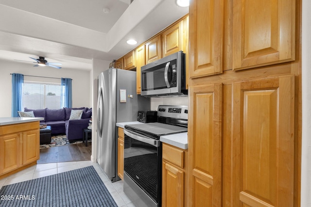 kitchen with ceiling fan, light tile patterned floors, and appliances with stainless steel finishes