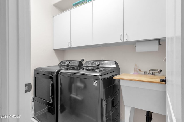 laundry area featuring cabinets, washer and clothes dryer, and sink