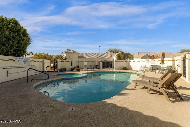 view of swimming pool with a patio area and a community hot tub