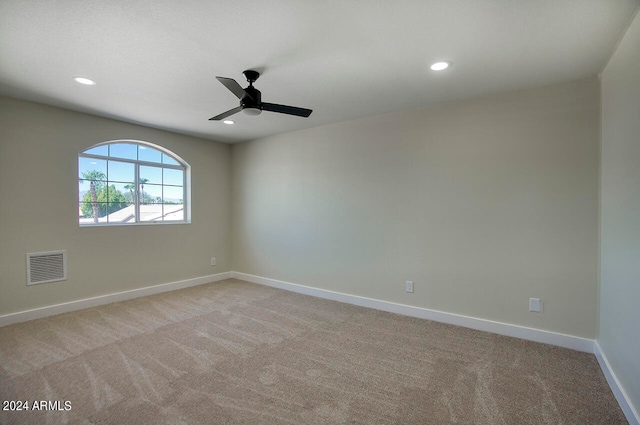 empty room featuring ceiling fan and light colored carpet