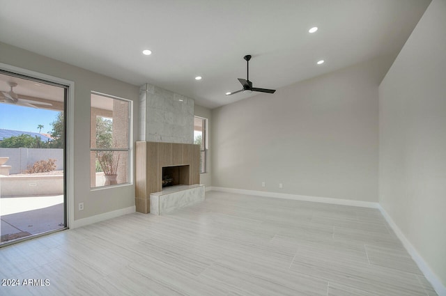 unfurnished living room with a fireplace and ceiling fan