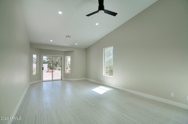 spare room with ceiling fan, vaulted ceiling, and light hardwood / wood-style floors