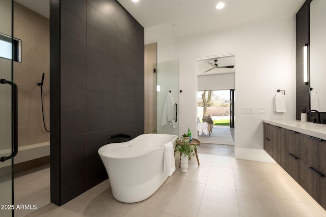 full bathroom with a shower stall, vanity, tile patterned floors, a soaking tub, and tile walls