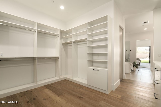 spacious closet featuring visible vents and wood finished floors