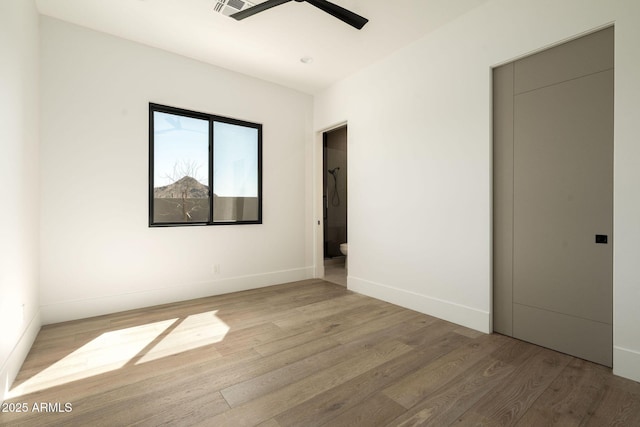 unfurnished room featuring visible vents, baseboards, light wood-style floors, and a ceiling fan