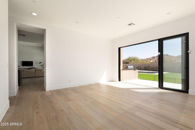 unfurnished room featuring recessed lighting, visible vents, baseboards, and light wood-style flooring