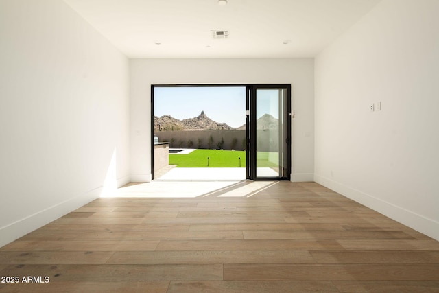 entryway featuring a mountain view, wood finished floors, visible vents, and baseboards