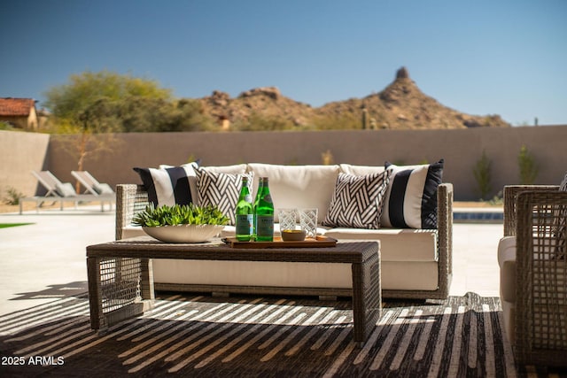 view of patio / terrace featuring fence, a mountain view, and an outdoor hangout area