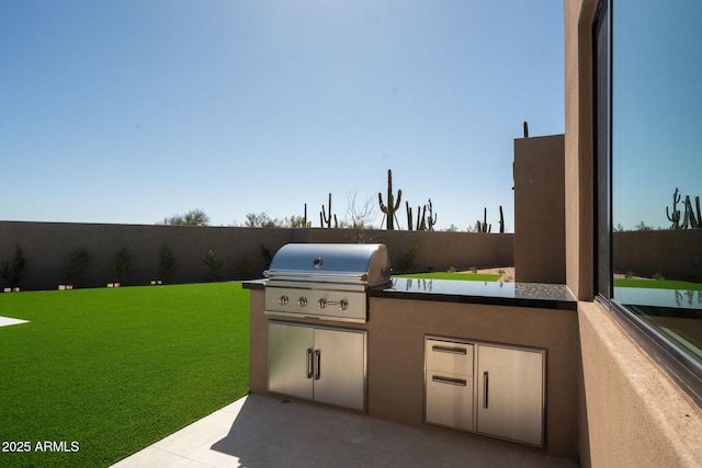 view of patio / terrace featuring area for grilling, exterior kitchen, and fence