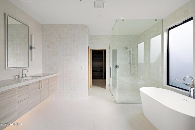 bathroom with vanity, shower with separate bathtub, tile patterned flooring, and tile walls