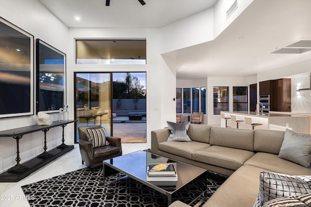 living room with a towering ceiling and ceiling fan