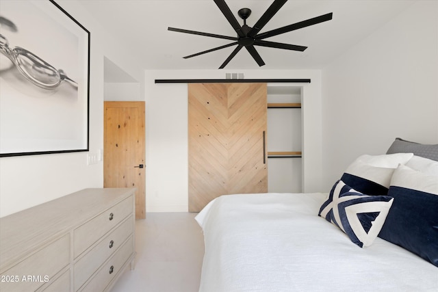 bedroom featuring a barn door and ceiling fan