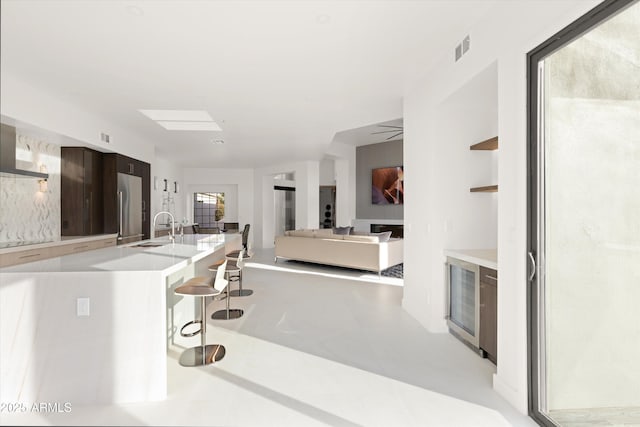 interior space with sink and wall chimney range hood