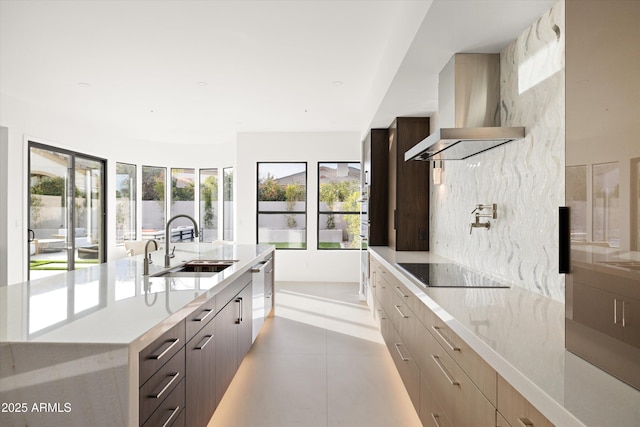 kitchen featuring wall chimney range hood, sink, plenty of natural light, black electric cooktop, and stainless steel dishwasher